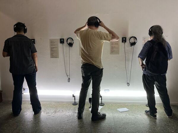 Three people listening on headphones